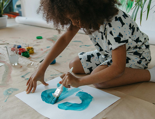 A young child doing some painting.